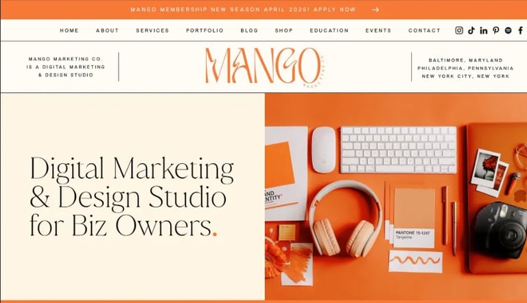 Mango design studio website header featuring creative workspace with orange headphones, keyboard, and marketing materials on bright orange background
